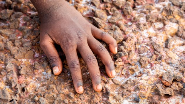 Single hand of a Young Indigenous girl on rocks , Australia